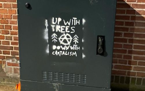 Een stencil van de sticker "UP WITH TREES, DOWN WITH CAPITALISM".