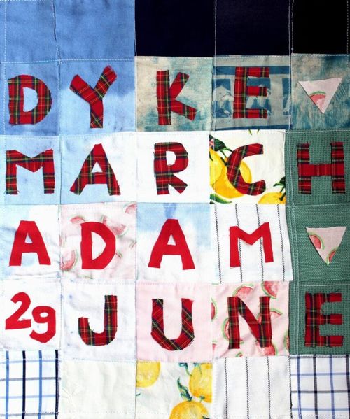 DYKE MARCH ADAM 29 JUNE
In checkered red cloth sown, each letter onto a grid of different cloths.

The grid of sown-together cloths, the ones higher up are bluer giving a bit of impression of sky. And the bottom a whiter Some have peaches on, the one under the N and D has melon pieces on it.